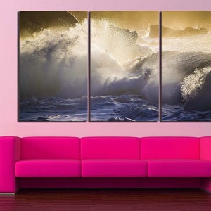 May include: A three-panel canvas print featuring a dramatic seascape with crashing waves and a golden glow. The waves are white and foamy, and the water is a deep blue. The print is perfect for adding a touch of nature to any room.
