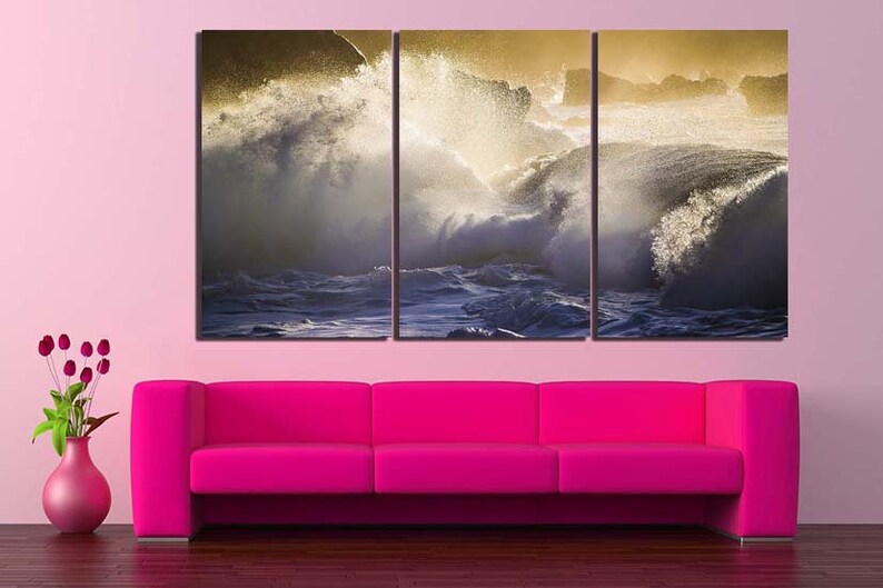 May include: A three-panel canvas print featuring a dramatic seascape with crashing waves and a golden glow. The waves are white and foamy, and the water is a deep blue. The print is perfect for adding a touch of nature to any room.