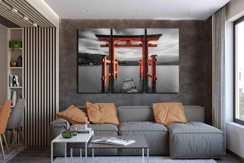 May include: A three-panel canvas print featuring a red Japanese Torii gate, a traditional gateway, standing in a body of water. The gate is surrounded by a black and white landscape with a cloudy sky.