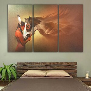 May include: A painting of a Native American woman with long dark hair wearing a feathered headdress, embracing a white and brown horse with a flowing mane. The background is a soft orange and yellow gradient.