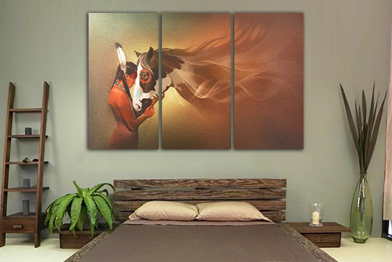 May include: A painting of a Native American woman with long dark hair wearing a feathered headdress, embracing a white and brown horse with a flowing mane. The background is a soft orange and yellow gradient.