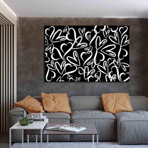 Puede incluir: Una impresi&oacute;n en lienzo en blanco y negro con un patr&oacute;n de corazones blancos sobre un fondo negro. La impresi&oacute;n est&aacute; colgada en una pared en un sal&oacute;n.