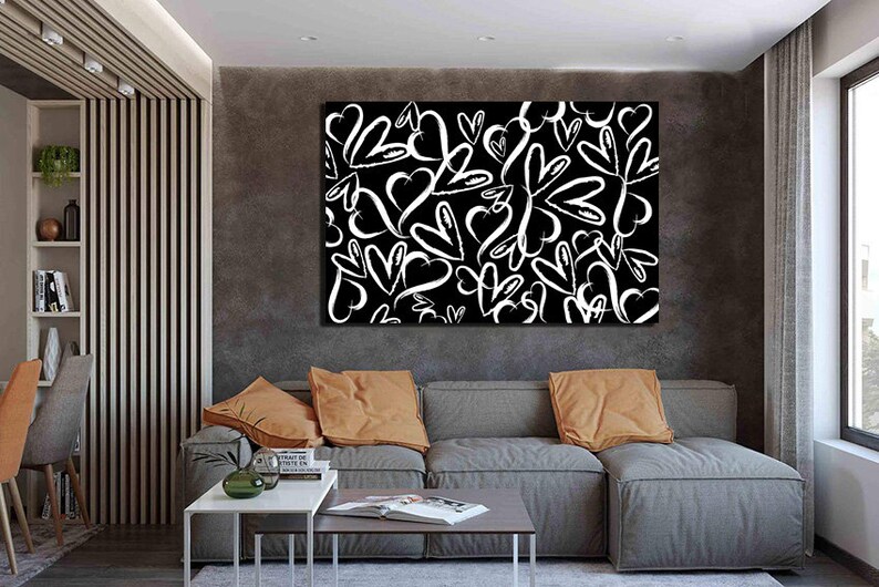 Puede incluir: Una impresi&oacute;n en lienzo en blanco y negro con un patr&oacute;n de corazones blancos sobre un fondo negro. La impresi&oacute;n est&aacute; colgada en una pared en un sal&oacute;n.