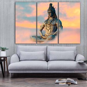 May include: A three-panel canvas print featuring a meditating figure of Shiva, a Hindu deity, against a backdrop of a colorful sunset sky.