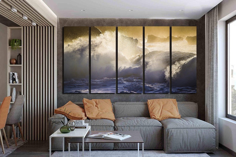 May include: A living room interior with a gray sectional sofa and a set of four canvas prints depicting crashing ocean waves with a golden glow.