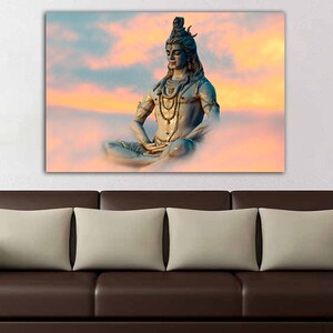 May include: A blue statue of Shiva meditating in a lotus position against a pink and orange cloudy sky.