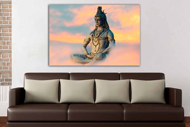May include: A blue statue of Shiva meditating in a lotus position against a pink and orange cloudy sky.