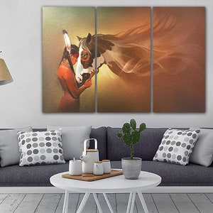 May include: A three-panel canvas print featuring a Native American woman with a headdress embracing a white and brown horse. The background is a soft orange and brown gradient.