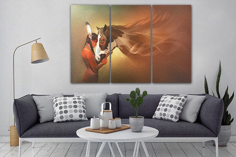 May include: A three-panel canvas print featuring a Native American woman with a headdress embracing a white and brown horse. The background is a soft orange and brown gradient.
