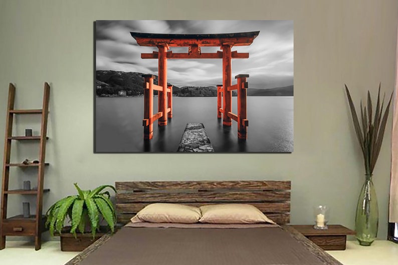 May include: A black and white photograph of a red Japanese Torii gate standing in a body of water. The gate is a traditional Japanese structure that is often found at the entrance to a shrine.