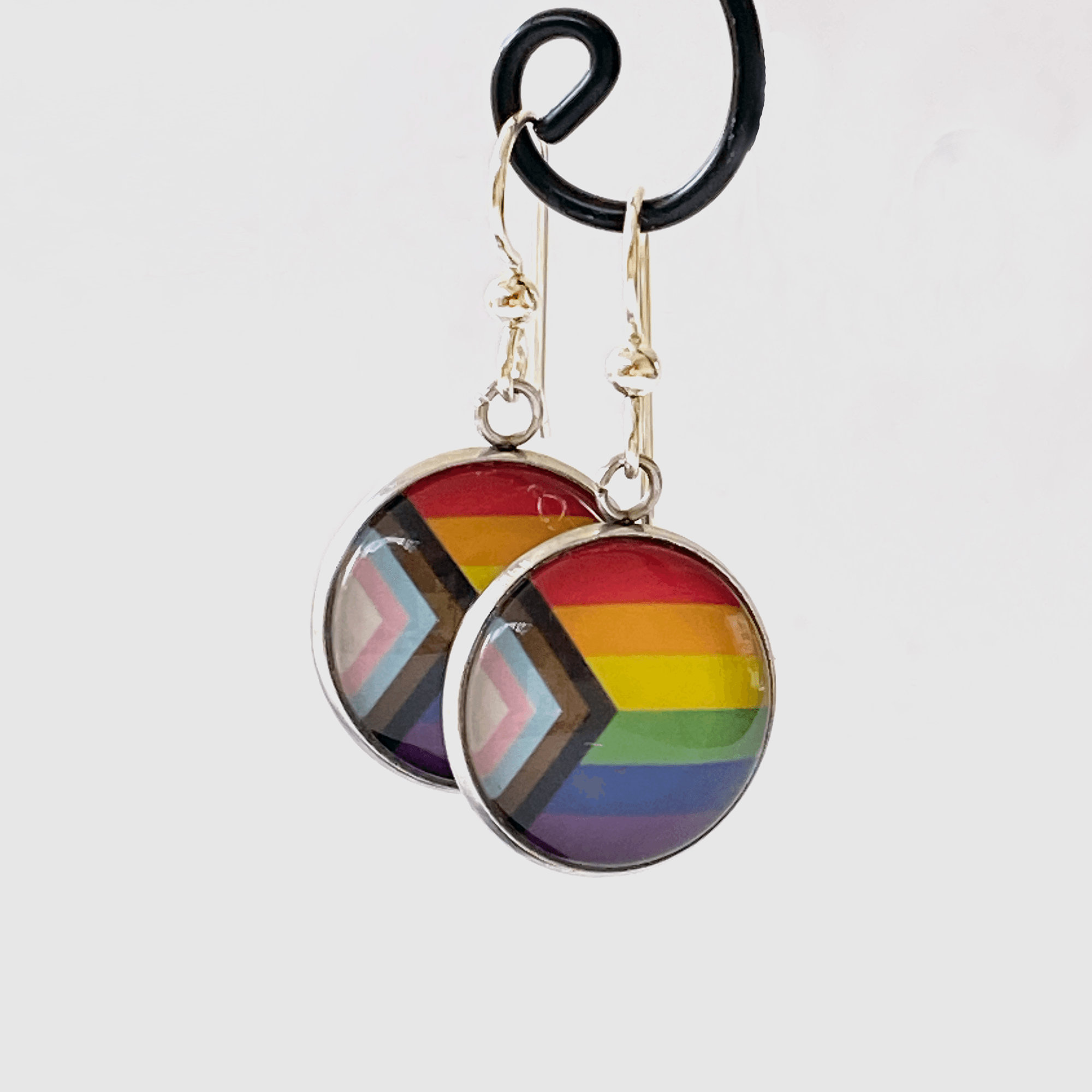 Pendientes de plata de ley con la bandera arcoíris del orgullo LGBTQ y el progreso inclusivo de las personas transgénero.