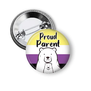 May include: A round button pin with a non-binary pride flag design. The pin features a yellow, white, purple, and black color scheme with the words "Proud Parent" and a bear illustration.