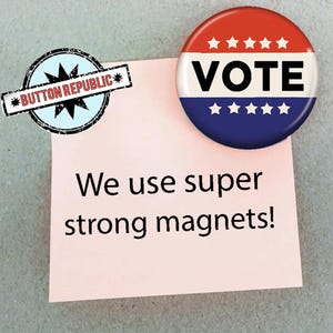a pink sticky note with the text "We use super strong magnets!" attached to it, along with a red, white, and blue button-shaped magnet that says "VOTE" on it.