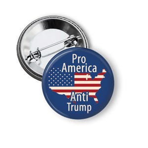 May include: A round, blue button with the text "Pro America Anti Trump" and a graphic of the American flag in the shape of the United States. The button has a metal pin back.