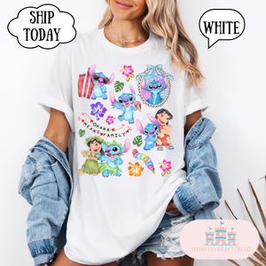 May include: White t-shirt with a colorful print of Stitch and other characters from Lilo & Stitch. The print includes the phrase "Ohana means family".