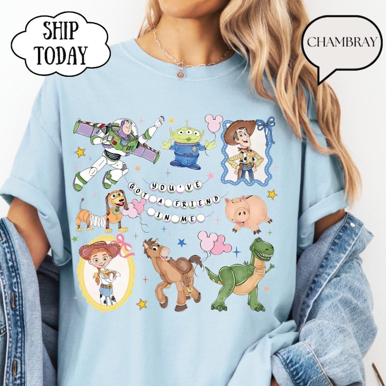 Puede incluir: Una camiseta azul claro con un estampado gr&aacute;fico de varios personajes animados, incluyendo un ranger espacial, un alien&iacute;gena verde, un vaquero, una vaquera, un perro salchicha, un cerdo, un caballo y un dinosaurio, con el texto "YOU'VE GOT A FRIEND IN ME".