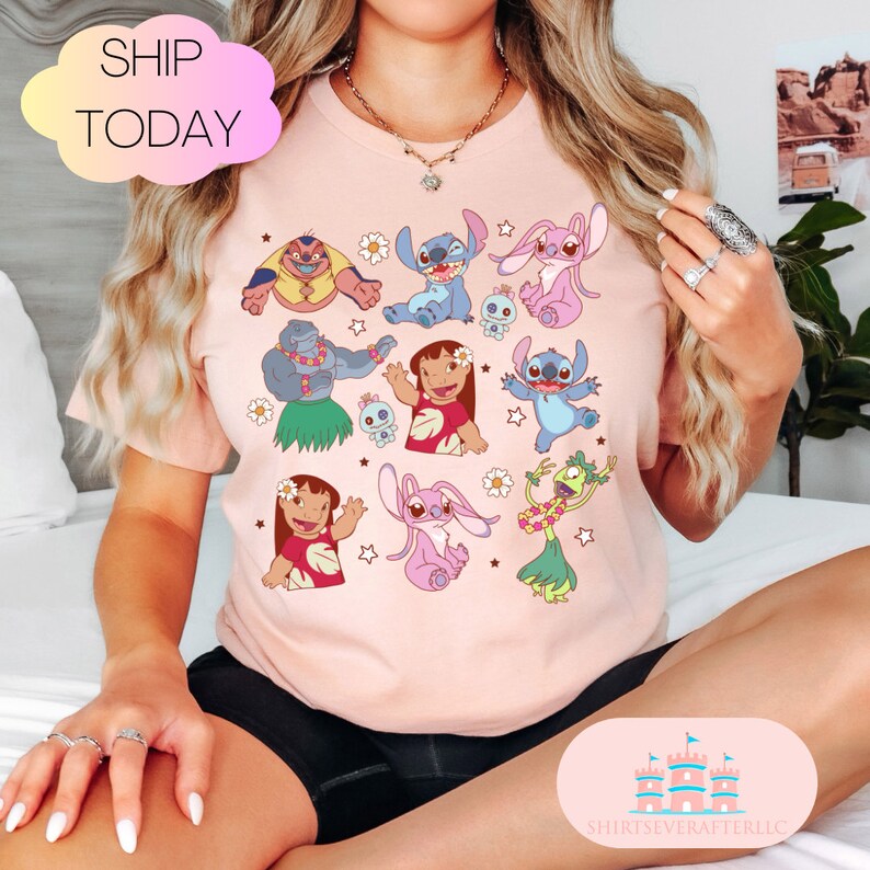 May include: Pink t-shirt with a variety of cartoon characters from the Disney movie Lilo & Stitch. The characters include Stitch, Angel, Lilo, and others. The shirt has a white background and the characters are in various colors.