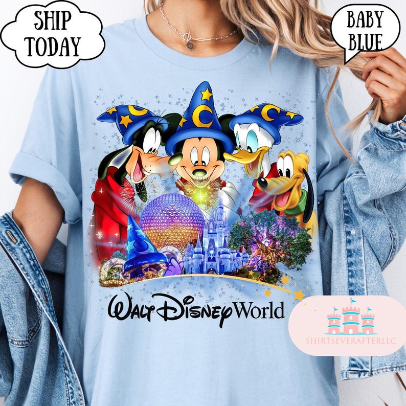 May include: Baby blue t-shirt featuring a colorful graphic of Mickey Mouse, Goofy, Donald Duck, and Pluto wearing wizard hats. The graphic includes the text "Walt Disney World" and a castle. The shirt has the text "Ship Today" in a cloud.