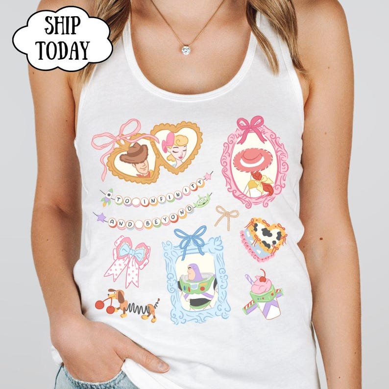 Op de afbeelding: Witte tanktop met kleurrijke cartoon illustraties van personages en elementen uit een populaire animatiefilm. Het ontwerp bevat ingelijste portretten, strikken en de zin "TO INFINITY AND BEYOND".