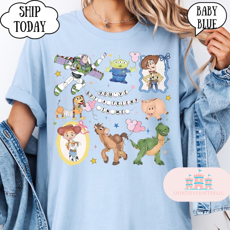 Puede incluir: Una camiseta azul claro con un estampado gr&aacute;fico de varios personajes animados, incluyendo un ranger espacial, un alien&iacute;gena verde, un vaquero, un perro salchicha, un cerdo, una vaquera, un caballo y un dinosaurio, con el texto "YOU'VE GOT A FRIEND IN ME".