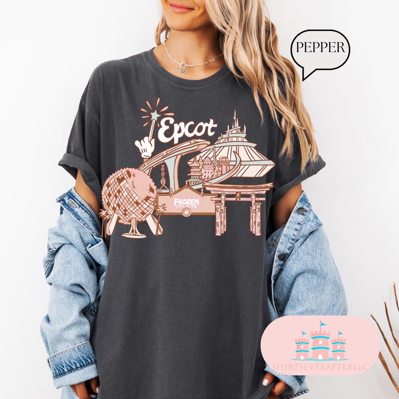May include: A dark grey t-shirt featuring a graphic of Epcot, a popular theme park in Orlando, Florida. The graphic depicts a stylised illustration of the park's iconic Spaceship Earth, the World Showcase Lagoon, and the Frozen Ever After ride. The text "Epcot" is printed in a pink font.