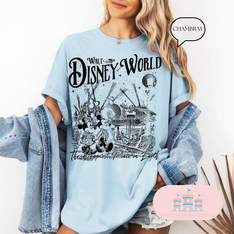 May include: Light blue t-shirt featuring a black and white graphic of Walt Disney World with Mickey and Minnie Mouse. The text "Walt Disney World" and "The Happiest Place on Earth" are also printed on the shirt.