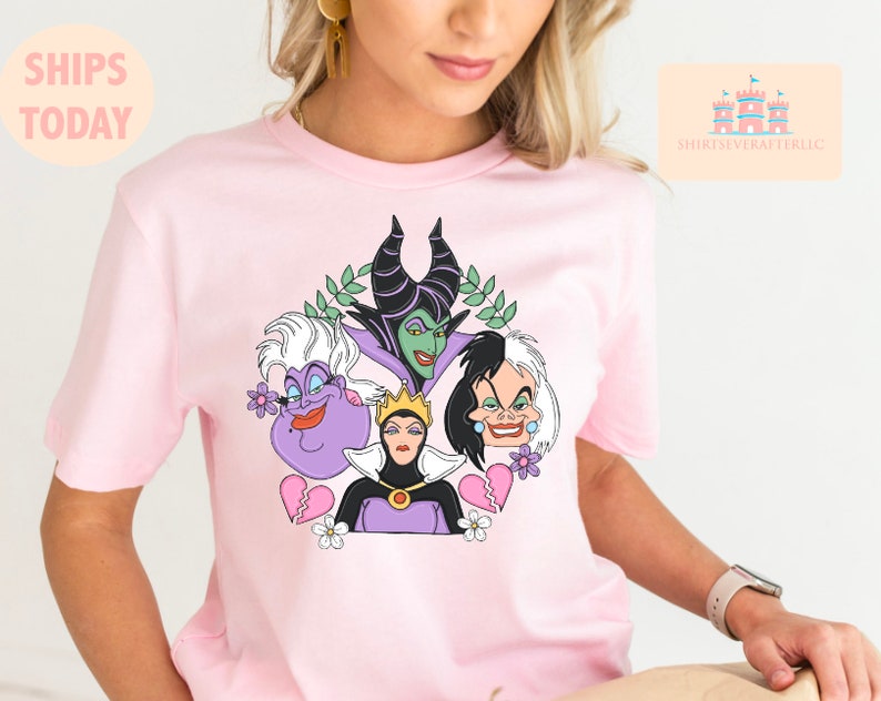 Puede incluir: Camiseta rosa con un gr&aacute;fico de cuatro personajes villanos de Disney: Mal&eacute;fica, &Uacute;rsula, Cruella de Vil y la Reina Malvada. Los personajes est&aacute;n rodeados de flores y corazones rotos.