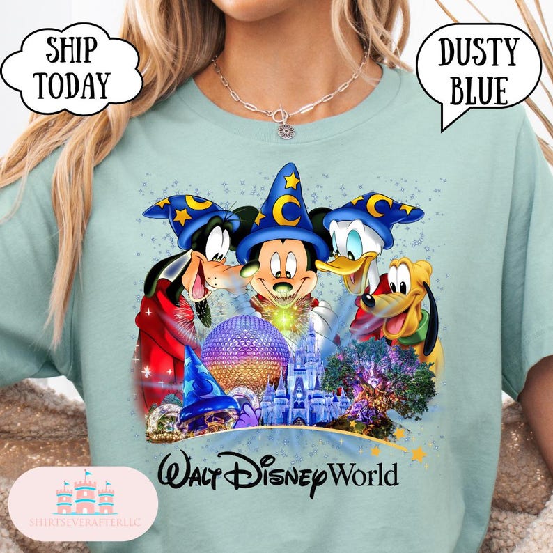 May include: Dusty blue t-shirt featuring Mickey Mouse, Goofy, Donald Duck, and Pluto wearing wizard hats. The shirt has the text "Walt Disney World" and the words "Ship Today" and "Dusty Blue" in speech bubbles.