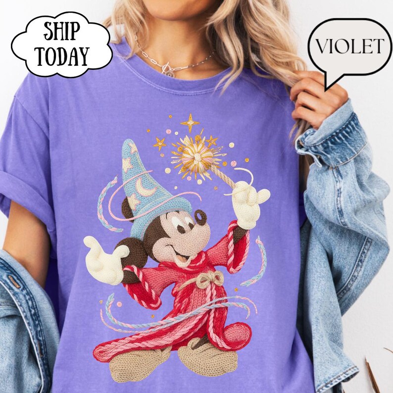 May include: A violet t-shirt with a cartoon Mickey Mouse in a wizard outfit, holding a wand with a starburst design. The shirt has the text "SHIP TODAY" in a cloud-shaped bubble. The word "VIOLET" is in a speech bubble.
