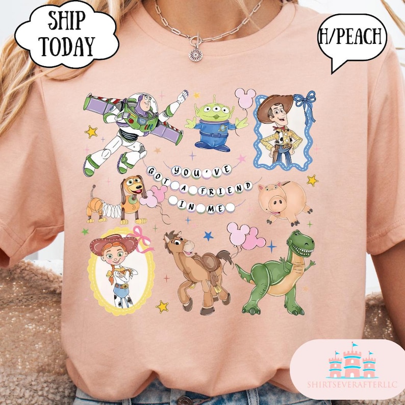Puede incluir: Una camiseta de color melocot&oacute;n con un estampado gr&aacute;fico de varios personajes animados, incluyendo un ranger espacial, un vaquero, una vaquera, un alien&iacute;gena verde, un dinosaurio, un cerdo, un perro y un caballo, con el texto "YOU'VE GOT A FRIEND IN ME".