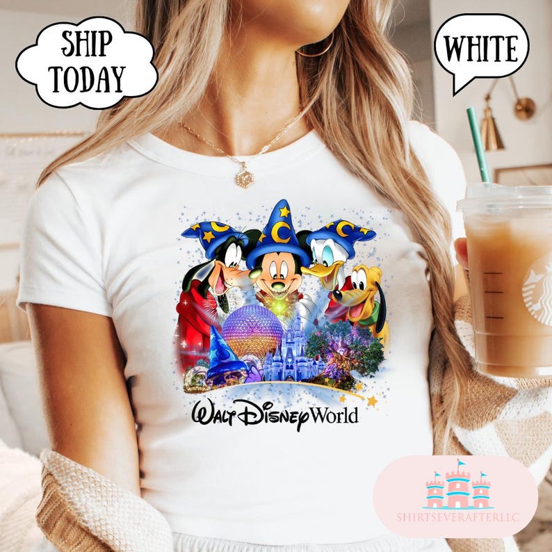 May include: White t-shirt featuring Mickey Mouse, Goofy, Donald Duck, and Pluto with a Walt Disney World graphic. The design includes a castle, a sphere, and stars. The shirt has the text "Walt Disney World".