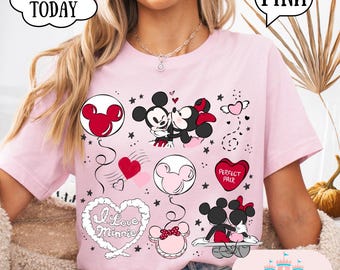 May include: Pink t-shirt featuring Mickey and Minnie Mouse graphics. The design includes heart-shaped balloons, the text "I Love Minnie," and the words "Perfect Pair." The shirt also has the text "SHIP TODAY" and "PINK."
