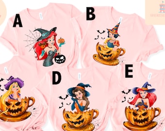 May include: Five pink t-shirts with different Disney princesses dressed as witches in a pumpkin teacup. The princesses are Ariel, Snow White, Belle, Rapunzel, and Cinderella. Each shirt has a letter on it, A through E.