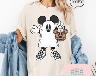 May include: A beige t-shirt featuring a cartoon ghost dressed as Mickey Mouse, carrying a jack-o'-lantern. The text "IVORY" is in a speech bubble above the image. The text "SHIRTSEVERAFTERLLC" is at the bottom of the image.