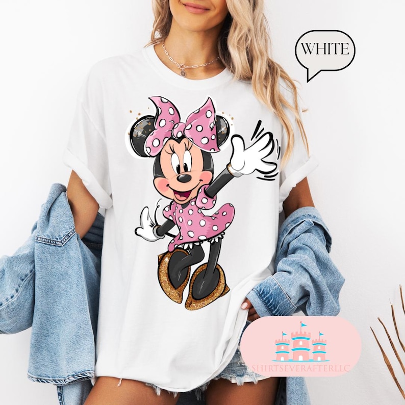 Puede incluir: Camiseta blanca con un gr&aacute;fico de Minnie Mouse con un vestido rosa de lunares y un lazo rojo. El texto "WHITE" est&aacute; en un cuadro blanco con un contorno negro.
