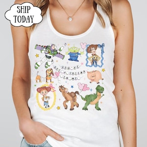 Puede incluir: Una camiseta sin mangas blanca con un estampado gr&aacute;fico colorido de varios personajes animados, incluyendo un ranger espacial, un vaquero, una vaquera, un alien&iacute;gena verde, un dinosaurio, un cerdo y un perro, con el texto "YOU'VE GOT A FRIEND IN ME".