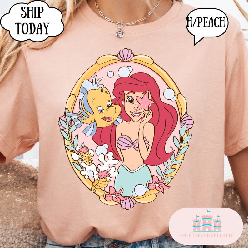 May include: Peach-colored t-shirt featuring a cartoon illustration of Ariel from The Little Mermaid, holding a starfish with Flounder. The design is framed in a gold oval with seashells and floral accents. The shirt has the text "H/PEACH".