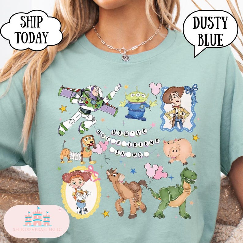 Puede incluir: Una camiseta azul polvoriento con un estampado gr&aacute;fico de los personajes de Toy Story, incluyendo a Buzz Lightyear, Woody, Jessie, Bullseye, Rex, Hamm, Slinky Dog y un Alien. El texto "YOU'VE GOT A FRIEND IN ME" aparece en el centro con estrellas.