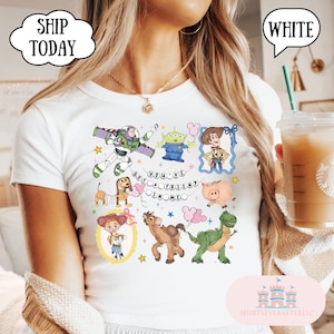 Puede incluir: Una camiseta blanca con un estampado gr&aacute;fico colorido de varios personajes animados, incluyendo un ranger espacial, un vaquero, una vaquera, un dinosaurio verde, un cerdo, un perro con cuerpo de muelle y un alien&iacute;gena, con el texto "YOU'VE GOT A FRIEND IN ME".