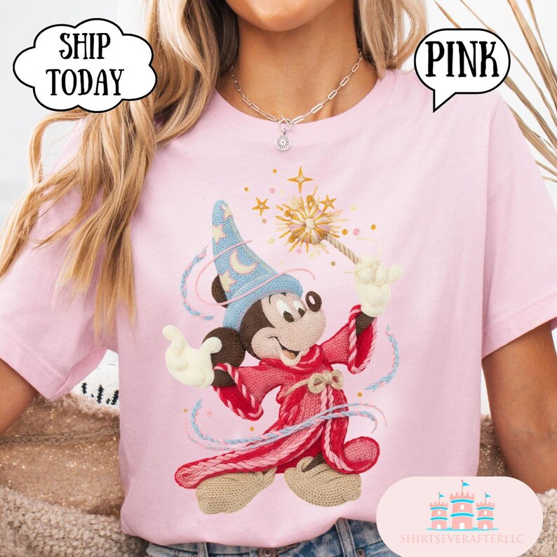 May include: Pale pink t-shirt with a cartoon Mickey Mouse wizard design, holding a wand with a starburst. The word "PINK" is in a speech bubble. The text "SHIP TODAY" is in a cloud-shaped bubble.