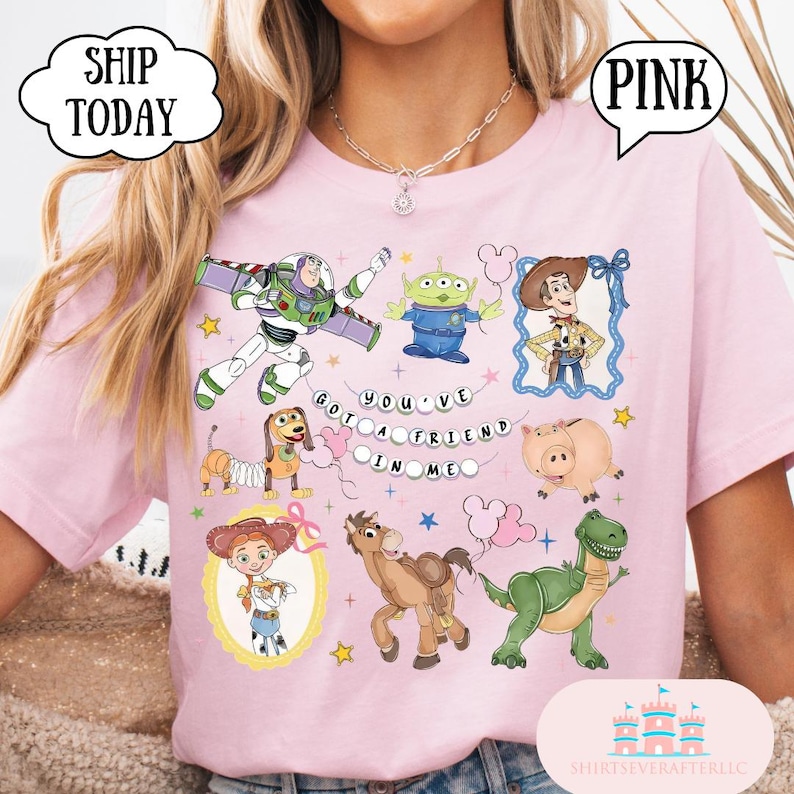 Puede incluir: Una camiseta rosa claro con un estampado gr&aacute;fico de varios personajes de Toy Story, incluidos Buzz Lightyear, Woody, Jessie, Slinky Dog, Rex, Hamm y un Alien. El texto "YOU'VE GOT A FRIEND IN ME" aparece en el centro con peque&ntilde;as estrellas.
