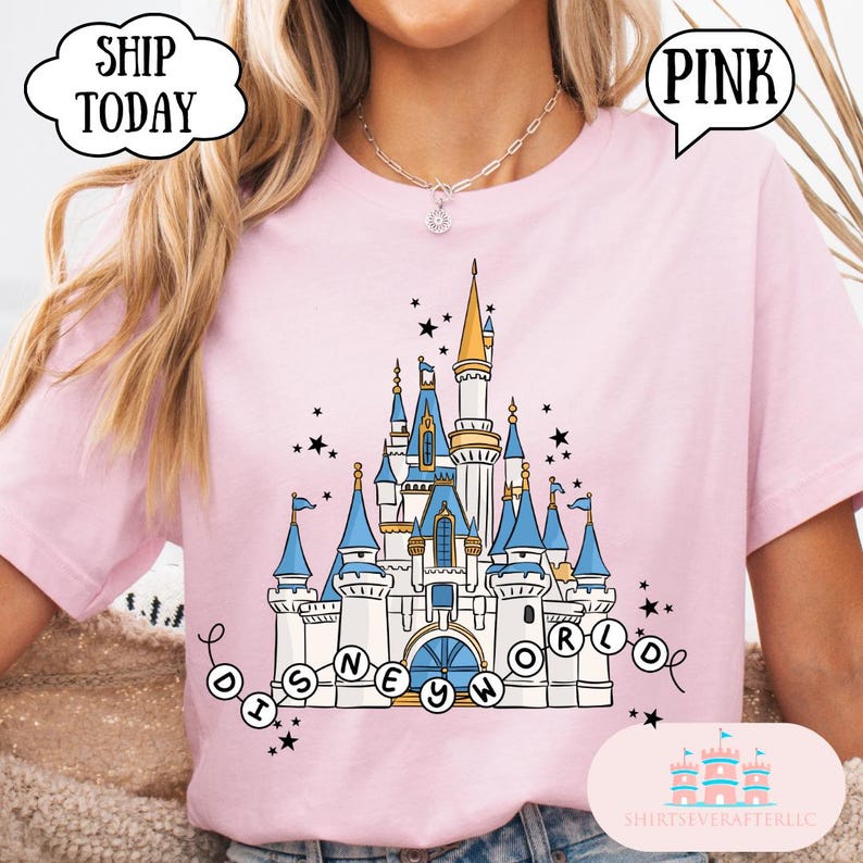 May include: Pink t-shirt featuring a whimsical castle design with blue turrets, gold accents, and the words "Disney World." The shirt includes the text "Ship Today" and "Pink."