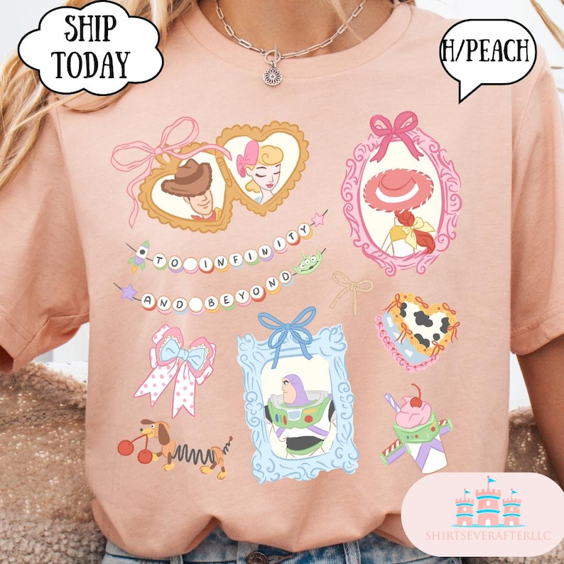 Op de afbeelding: Een perzikkleurig T-shirt met illustraties van stripfiguren in kaders en een banner met de tekst "TO INFINITY AND BEYOND". Het ontwerp bevat een hartvormig kader met een cowboy en een prinses, en een Buzz Lightyear-afbeelding.