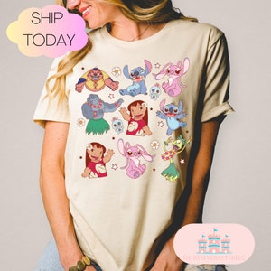 May include: A beige t-shirt with a colorful print of Stitch and other characters from the Disney movie Lilo & Stitch. The print includes Stitch, Angel, Jumba, and Lilo.