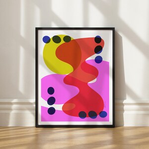May include: Abstract art print featuring a yellow, red and pink design. The print includes a yellow circle with a red and pink abstract shape overlapping it. The background is white with blue circles scattered throughout.