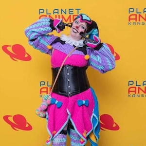 May include: A white ceramic mug with a black handle and the text "But First, Coffee" in a bold, black font. The mug is set against a blurred background, suggesting a cozy setting.