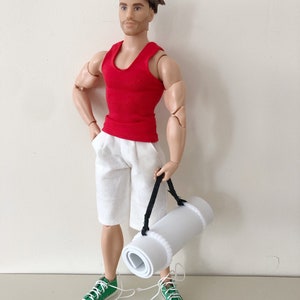 May include: A red tank top, white shorts, and green sneakers. A white yoga mat is rolled up and carried by a black strap.