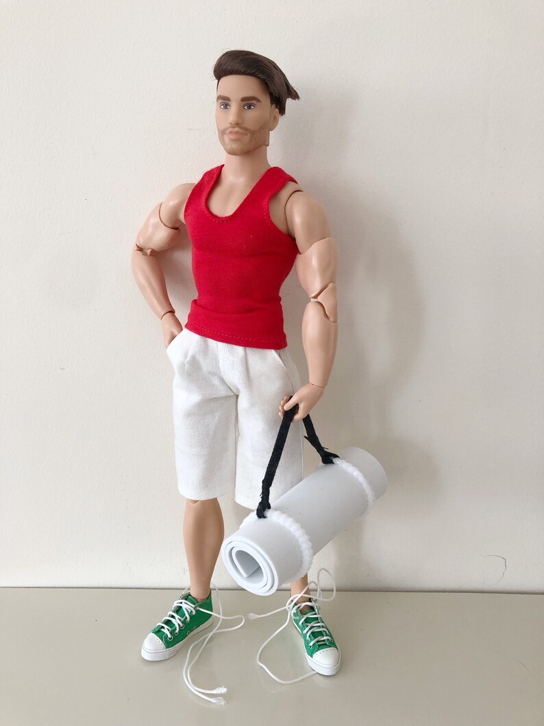 May include: A red tank top, white shorts, and green sneakers. A white yoga mat is rolled up and carried by a black strap.