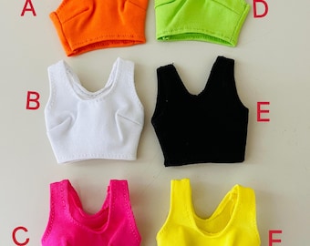 May include: Six sleeveless crop tops in various colors labeled A through F. The tops are orange, white, black, neon green, hot pink, and yellow. Each top features a scoop neckline, ribbed texture, and stitched bust detailing on the front.