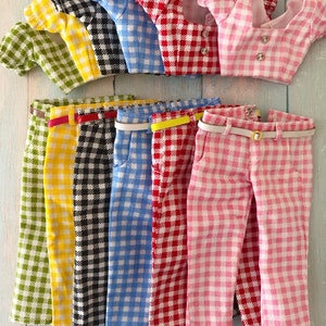 May include: Six sets of doll clothing featuring a gingham pattern in green, yellow, black, blue, red, and pink. Each set includes a short-sleeved crop top with two buttons and matching trousers with a thin belt. The sets are labeled A through F.